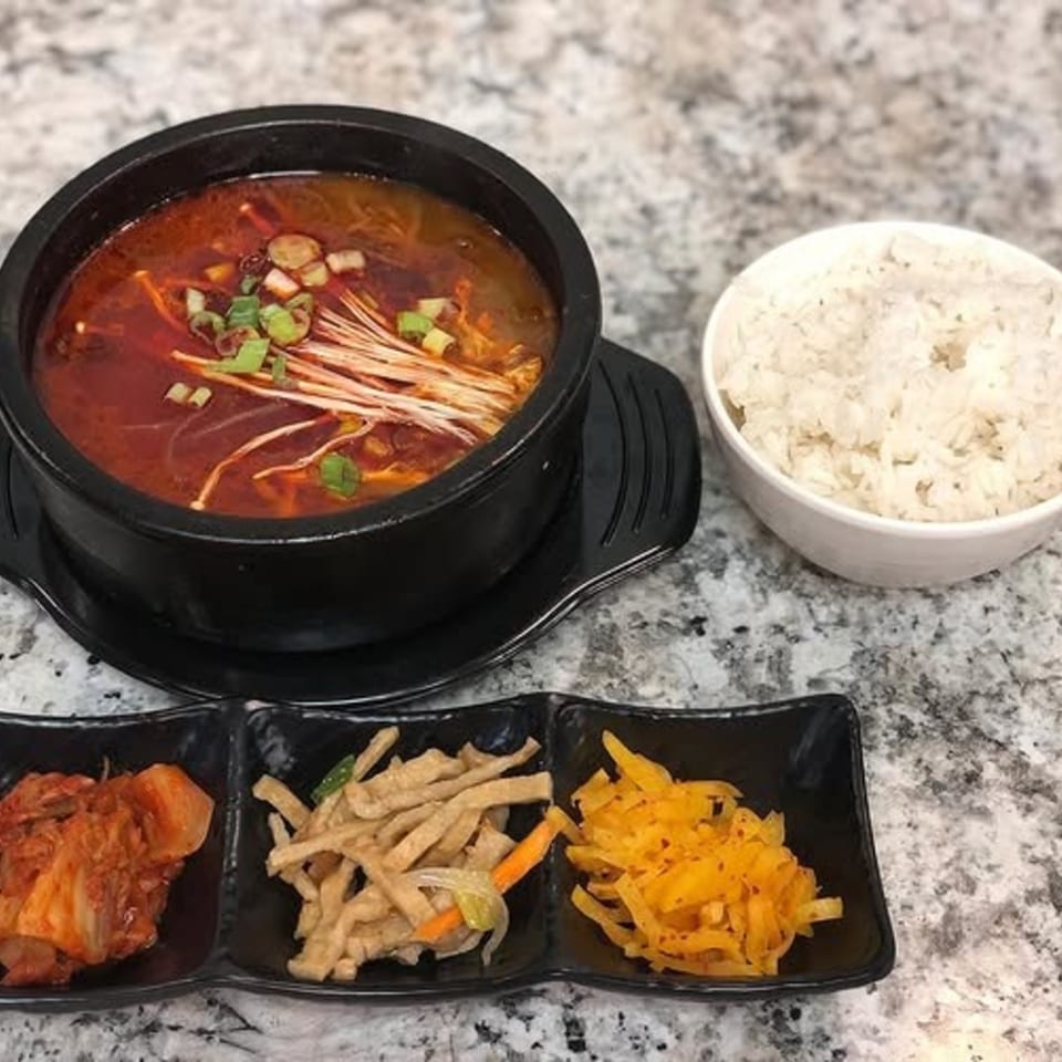 A Korean spicy soup with enoki mushrooms and green onions, served with rice and three side dishes.